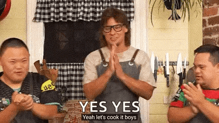 A Man In An Apron Is Standing In Front Of Two Boys With Down Syndrome And Clapping . GIF