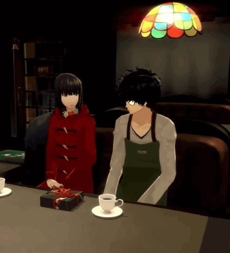 A Man In An Apron Sits Next To A Woman In A Red Coat GIF