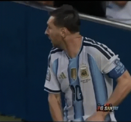 a man in an argentina jersey holds a stack of money in his hands