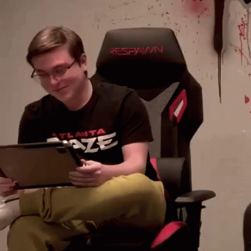 A Man In An Atlanta Blaze Shirt Is Sitting In A Chair GIF