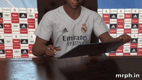 A Man In An Emirates Fly Better Shirt Signing A Contract GIF