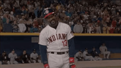A Man In An Indians Baseball Uniform Is Standing On A Baseball Field In Front Of A Crowd . GIF
