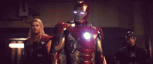 A Man In An Iron Man Suit Stands Between Two Other Men GIF