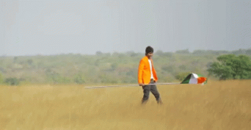 a man in an orange jacket is holding an indian flag