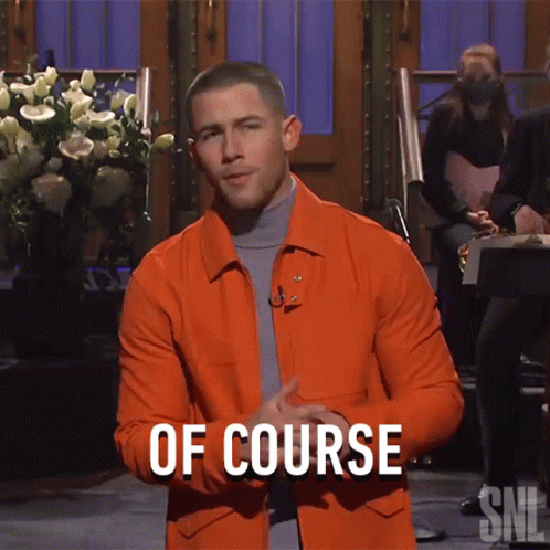A Man In An Orange Jacket Stands In Front Of A Sign That Says " Of Course " GIF