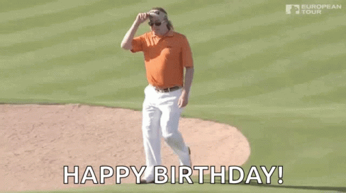 A Man In An Orange Shirt And White Pants Is Standing On A Baseball Field And Says `` Happy Birthday '' . GIF