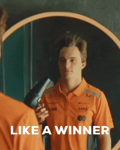 A Man In An Orange Shirt Holds A Hair Dryer In Front Of A Mirror With The Words Like A Winner Below Him GIF