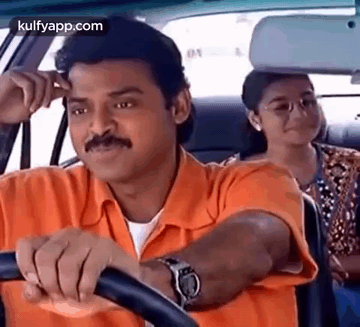 A Man In An Orange Shirt Is Driving A Car With A Woman Sitting In The Back Seat . GIF
