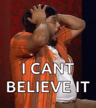 A Man In An Orange Shirt Is Holding His Head And Says I Can 'T Believe It . GIF