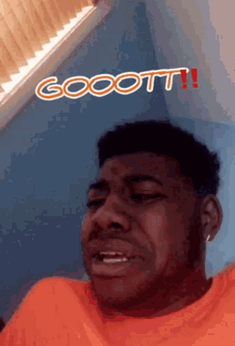 A Man In An Orange Shirt Is Making A Funny Face With The Words Goott Written Above Him GIF