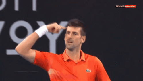 A Man In An Orange Shirt Is Pointing At His Head In Front Of A Tennis Highlights Sign GIF