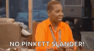A Man In An Orange Shirt Is Sitting At A Table And Saying No Pinkett Slander . GIF