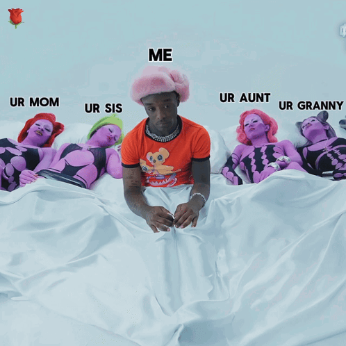 A Man In An Orange Shirt Is Sitting On A Bed Surrounded By Purple Women GIF