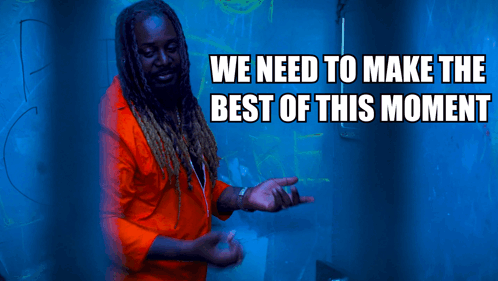 A Man In An Orange Shirt Is Standing In Front Of A Blue Background With The Words We Need To Make The Best Of This Momen GIF