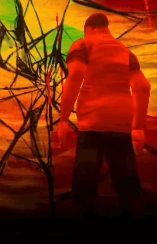 A Man In An Orange Shirt Is Standing In Front Of A Colorful Background GIF