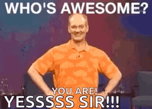 A Man In An Orange Shirt Is Standing With His Hands On His Hips And Says Who 'S Awesome ? GIF