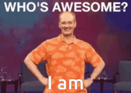 A Man In An Orange Shirt Is Standing With His Hands On His Hips With The Words Who 'S Awesome I Am Below Him GIF