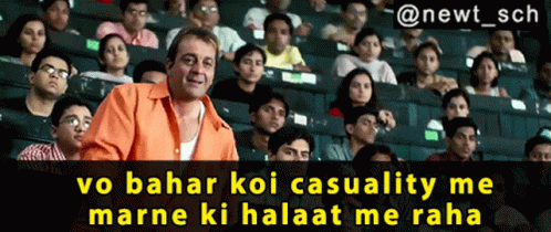 A Man In An Orange Shirt Stands In Front Of A Crowd Of People With The Caption " @Newt_sch GIF
