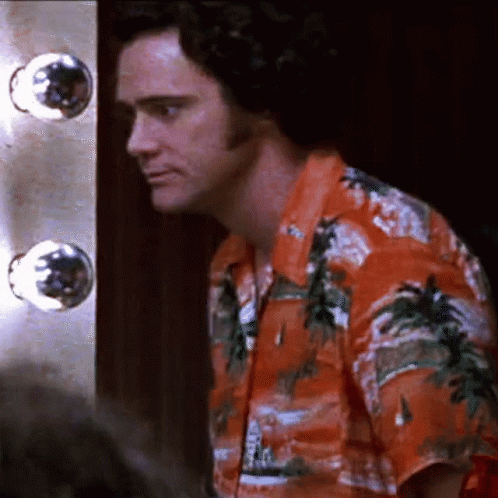 A Man In An Orange Shirt With Palm Trees On It GIF