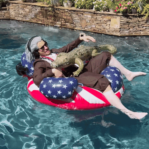 A Man In An Uncle Sam Costume Is Floating On An American Flag Raft In A Pool GIF