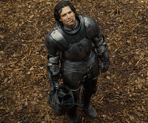 A Man In Armor Is Holding A Helmet And Smoking A Cigar GIF