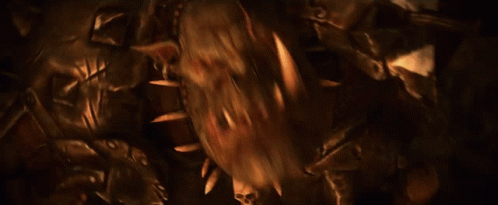 A Man In Armor Is Holding A Large Axe In His Right Hand GIF