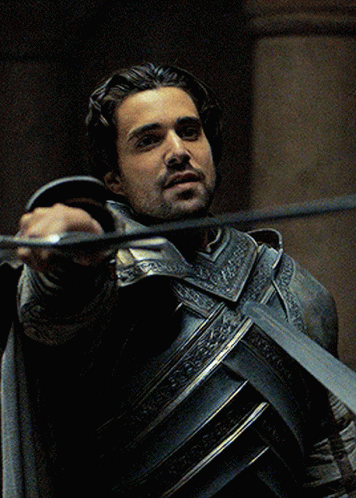 A Man In Armor Is Holding A Sword GIF