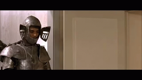 A Man In Armor Is Standing In Front Of A White Door GIF