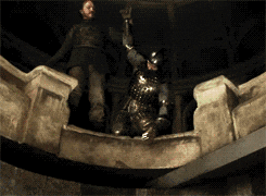 A Man In Armor Is Standing On A Ledge Holding A Sword GIF