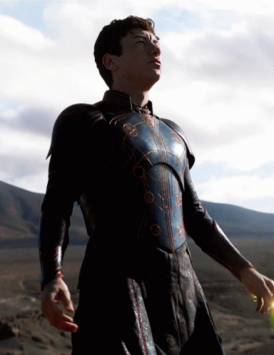 A Man In Armor Stands In A Desert Looking Up At The Sky GIF