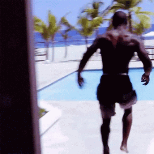 A Man In Black Shorts Is Running Towards A Pool GIF