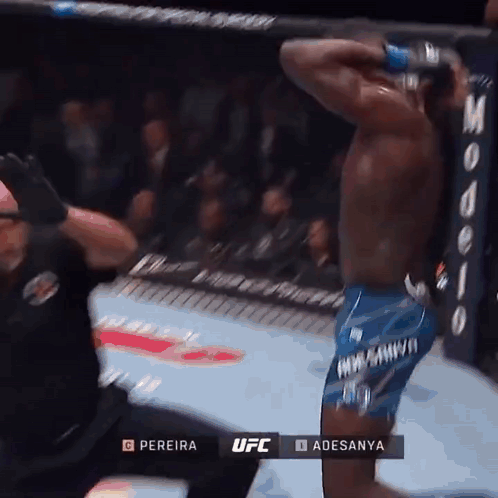 A Man In Blue Shorts Is Kneeling Down In A Boxing Ring During A Ufc Fight GIF