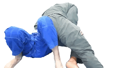 a man in blue shorts is wrestling another man in a grey shirt