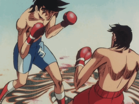 A Man In Boxing Gloves With The Letter T On His Shirt GIF