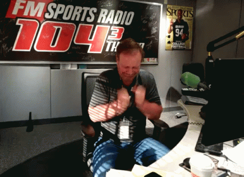 A Man In Front Of A Fm Sports Radio Sign GIF