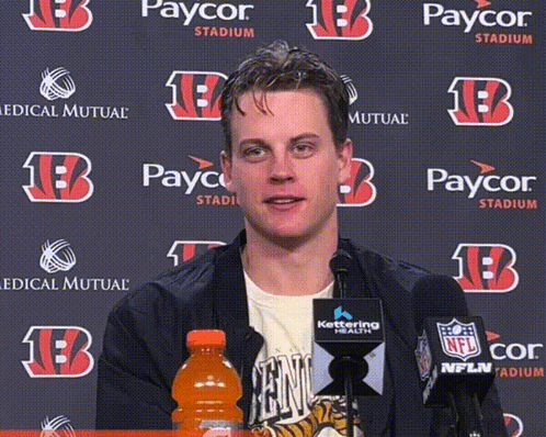 A Man In Front Of A Paycor Stadium Backdrop GIF