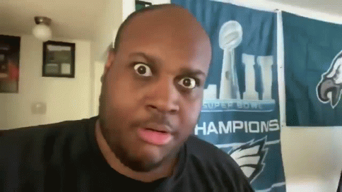 A Man In Front Of A Super Bowl Champions Flag GIF