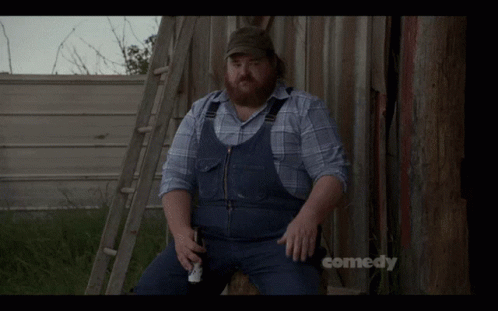 A Man In Overalls Is Sitting On A Ladder With The Words Allegedly Above Him GIF