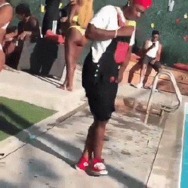 A Man In Overalls Is Standing Next To A Swimming Pool . GIF