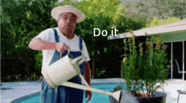 A Man In Overalls Is Watering Plants With A Watering Can . GIF