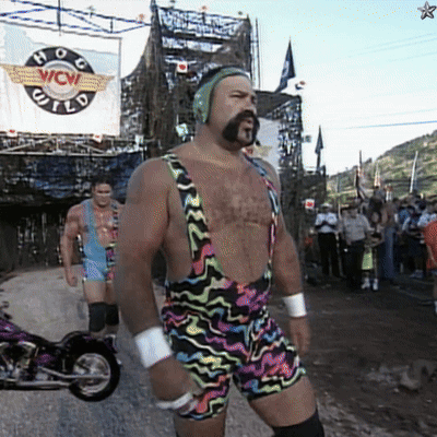 A Man In Overalls Stands In Front Of A Sign That Says Wow GIF