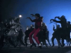 A Man In Red Pants Is Dancing With A Group Of Zombies GIF