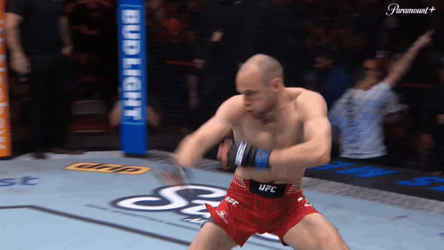 A Man In Red Shorts That Say Ufc Is Dancing On A Boxing Ring GIF