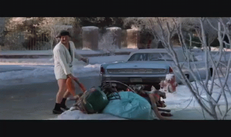 A Man In Shorts Is Shoveling Snow In Front Of A Ford GIF