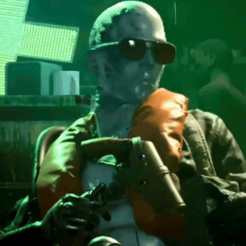 A Man In Sunglasses Is Holding A Gun GIF