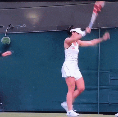 A Man In Sunglasses Is Standing Next To A Woman In A White Dress On A Tennis Court GIF
