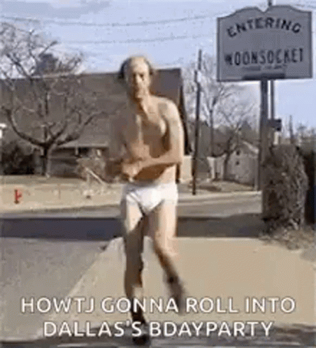 A Man In Underwear Is Running Down A Street . GIF