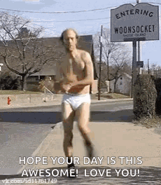 A Man In Underwear Is Running Down The Street . GIF