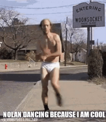 A Man In Underwear Is Running Down The Street . GIF
