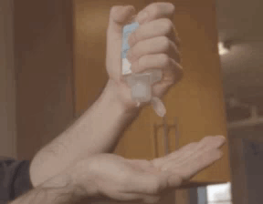 A Man Is Applying Hand Sanitizer To His Hand GIF
